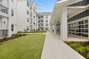 an exterior view of an apartment building with a lawn and walkwayat Oak Grove at Blake Farm, Wilmington, North Carolina